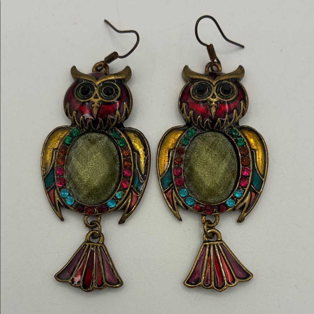 Brass-toned owl dangle earrings with multicolor enamel and rhinestone accents.